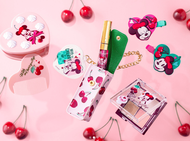 Bright Minnie Mouse themed lipstick and accessories with cherry accents.