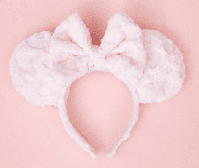 Adorable pink Minnie Mouse ears headband with plush bow, ideal for Disney costume accessories and themed parties.
