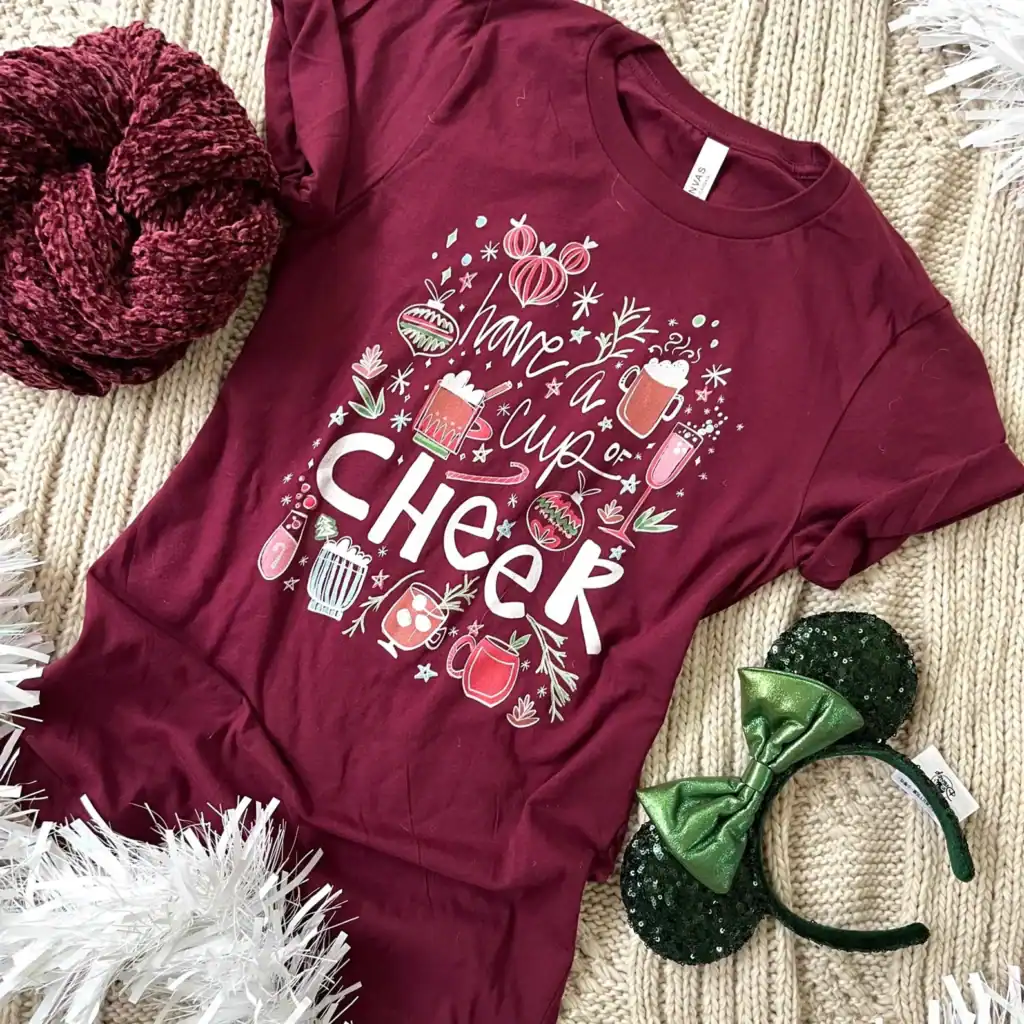 Festive holiday t-shirt with Christmas drink graphics, holiday theme, perfect for Disney fans and seasonal outfits.