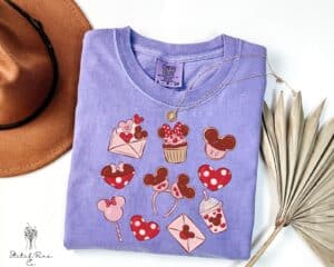 Colorful Disney Minnie Mouse Valentine's Day graphic tee with hearts, cupcakes, and love-themed icons.