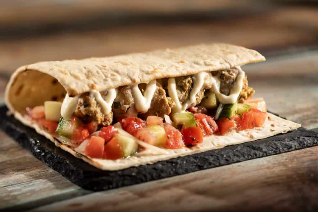 Delicious beef quesadilla filled with cheese and fresh vegetables, served on a rustic wooden surface.
