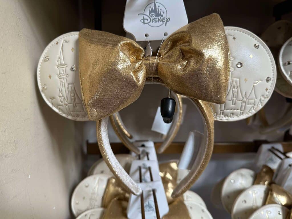 Disney Minnie Mouse ears headband with gold bow and castle design, ideal for Disney fashion enthusiasts.
