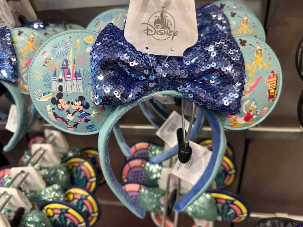 Colorful Disney themed Minnie Mouse ears headband with sparkling blue sequin bow, perfect for Disney fans.