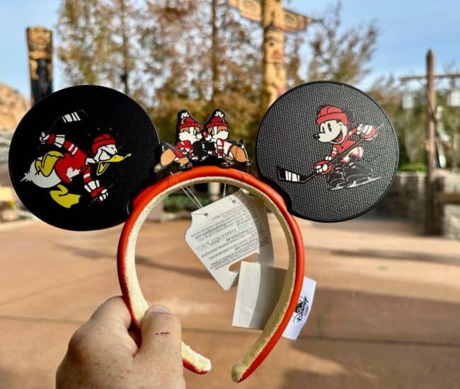 Mickey Mouse ears headband featuring cartoon sports graphics, ideal for Disney merchandise enthusiasts.