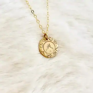 Gold Disney-inspired necklace with fiery silhouette charm and floral accents.