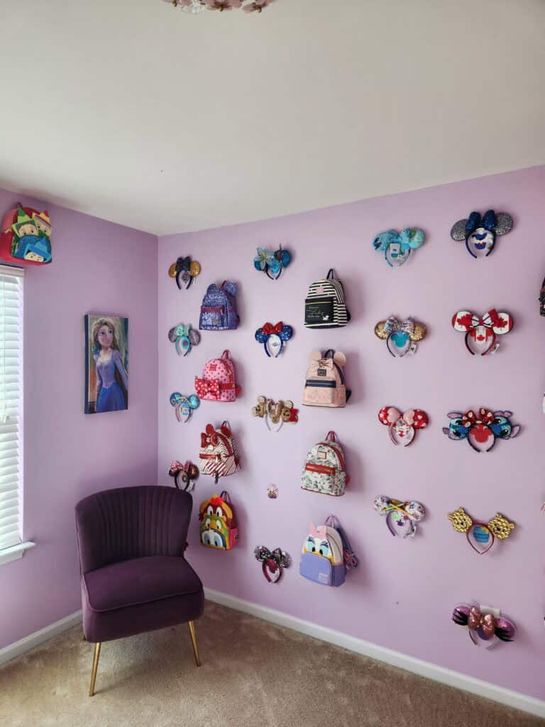 Colorful Disney-themed backpacks arranged on a lavender wall for a magical bedroom decor.