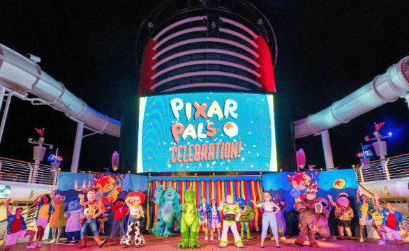 Disney Pixar characters celebrating on a cruise ship deck at night.