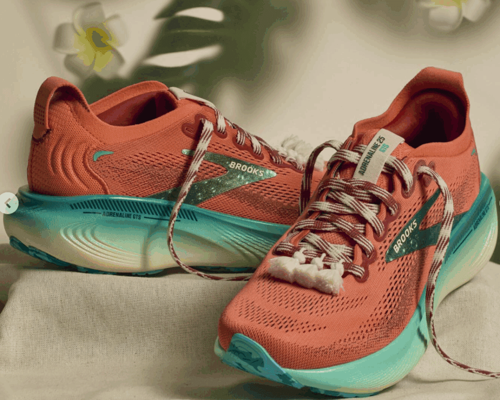 Athletic Brooks running shoes with coral upper and aqua sole, perfect for active wear and outdoor ru.