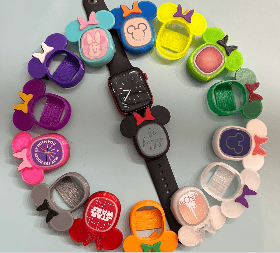 Colorful Disney-inspired Apple Watch band featuring Minnie Mouse ears and playful charms.