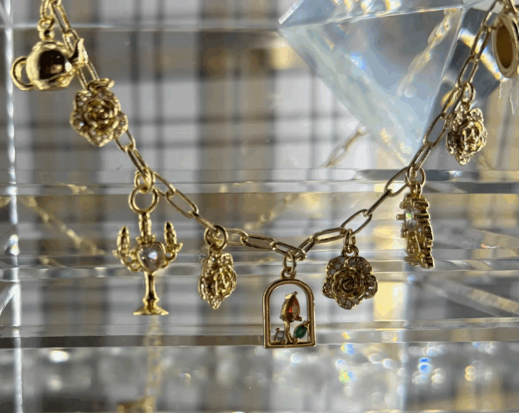 Charm bracelet featuring Disney-themed miniatures and a lock, perfect for Disney fashion enthusiasts.