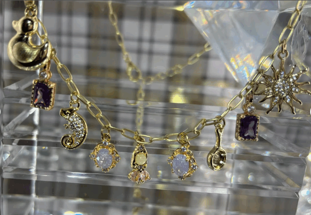 Elegant Disney-themed jewelry with gold chains and gemstone charms.