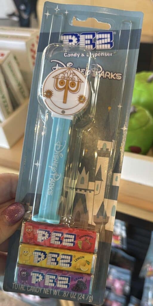 Disney Parks pin and candy set featuring a Tinker Bell design and colorful candies.