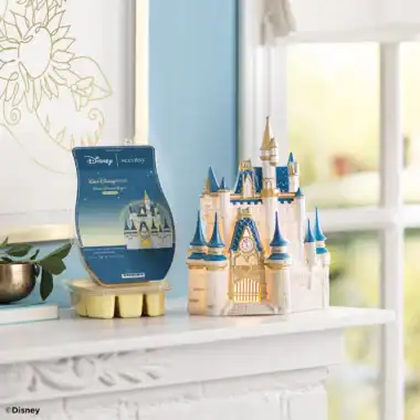 Disney castle-shaped Scentsy warmer on a white shelf with window background.