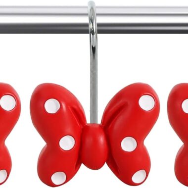 Red plush bows with white polka dots hanging on a metal rod.