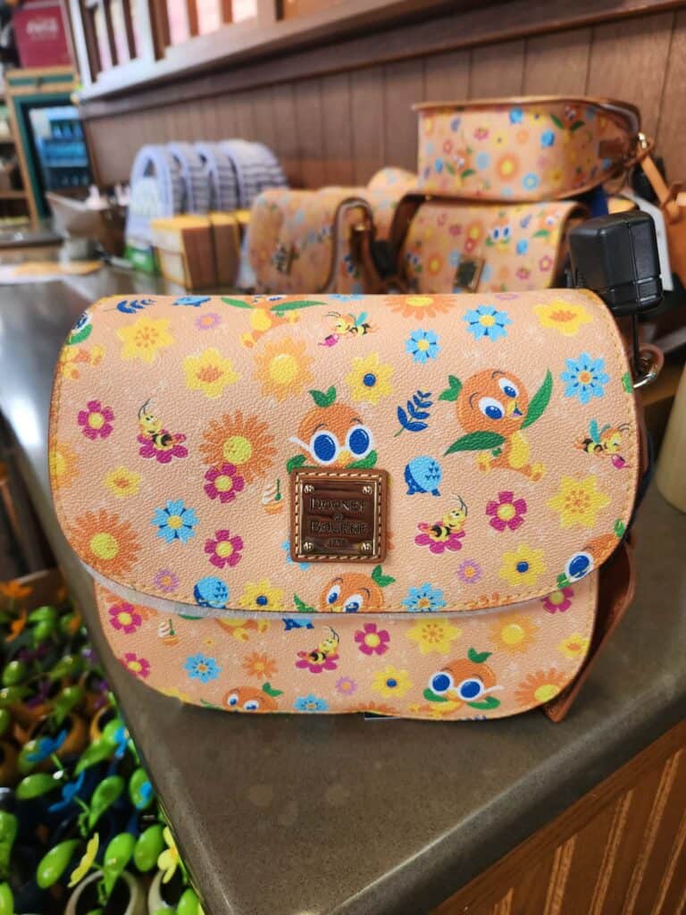 Colorful Disney-themed floral crossbody bag with animal prints and adjustable strap.