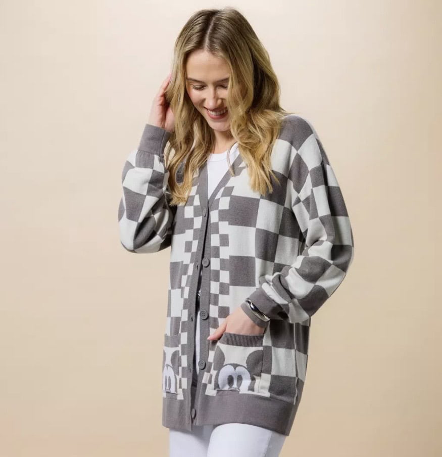 Woman wearing a stylish gray and white checkered Disney-themed cardigan.