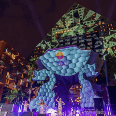 Vibrant outdoor stage at Disney Swan and Dolphin with colorful lighting and a giant animal sculpture.
