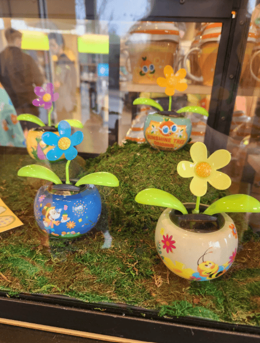 Bright solar-powered flowerpots with Disney-themed designs and vibrant flowers, ideal for outdoor de.