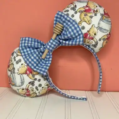 Cute Winnie the Pooh themed headband with blue gingham bow and honey pot print.