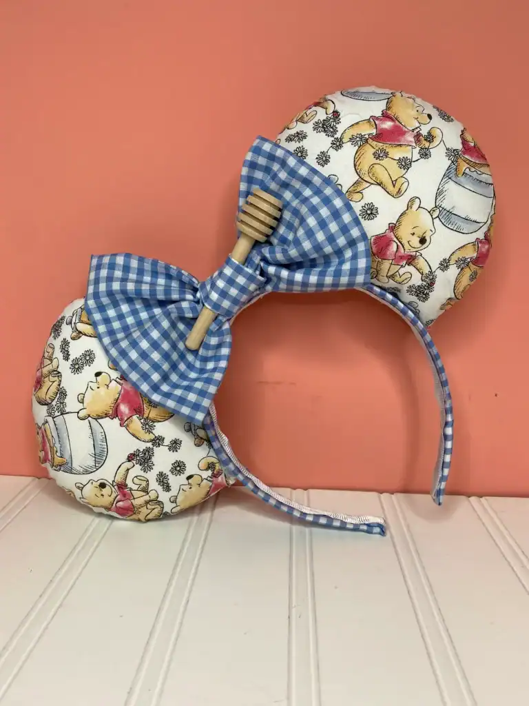 Cute Winnie the Pooh themed headband with blue gingham bow and honey pot print.