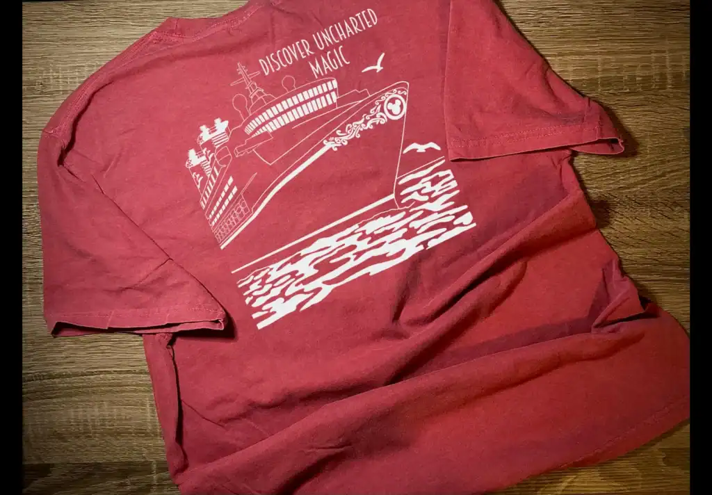 Unisex red T-shirt with white Disney-inspired design featuring a ship and ocean waves. Perfect for D.