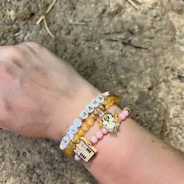 Colorful Disney-themed beaded bracelets on a child's wrist.
