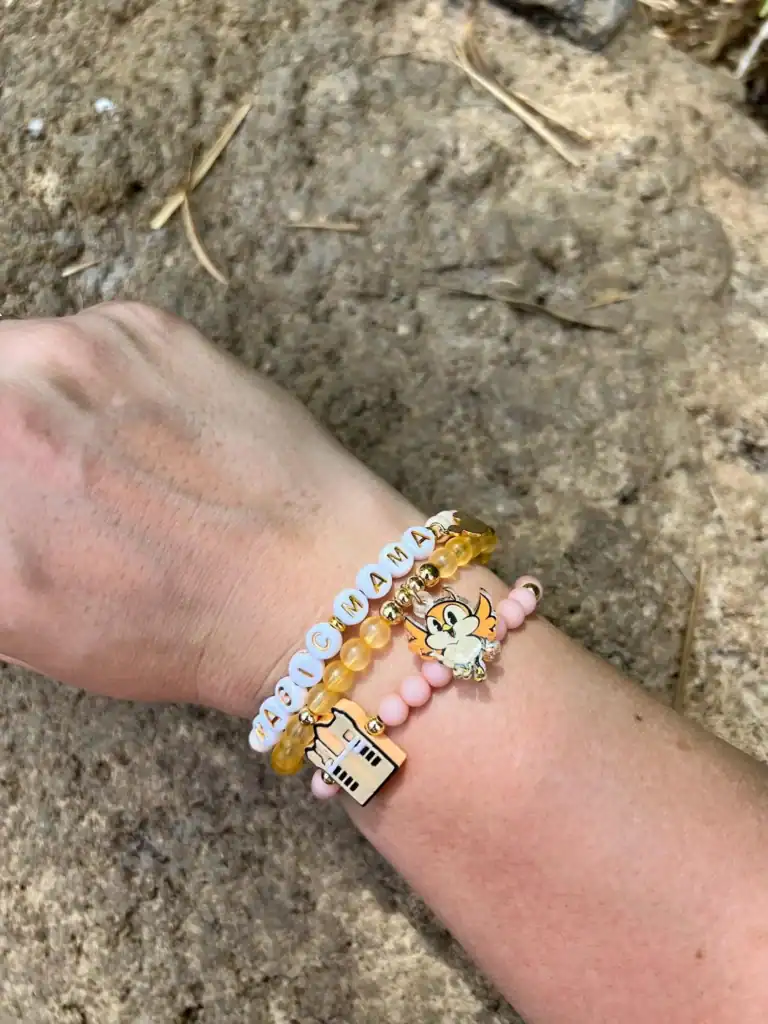 Colorful Disney-themed beaded bracelets on a child's wrist.