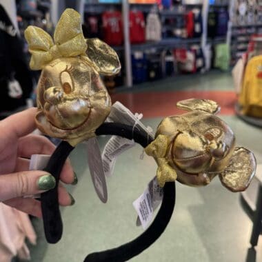 Gold Minnie Mouse headband with bow and ears, perfect Disney accessory for fans.