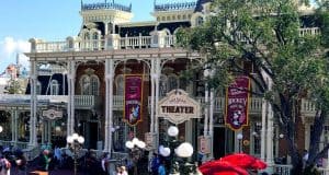 Main Street’s ornate Victorian theater at Magic Kingdom, decked in bright banners, welcomes crowds of excited Disney guests.