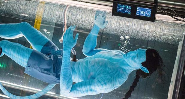An Avatar floats in a futuristic water tank with high-tech monitors above, evoking Pandora – The World of Avatar at Animal Kingdom.