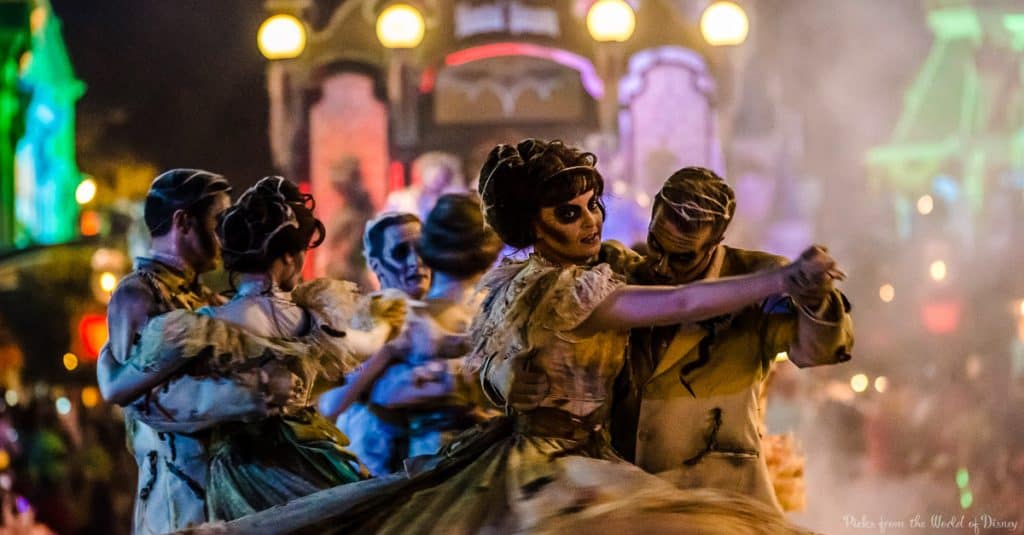 Zombie-costumed dancers waltz through a vibrant Halloween parade at Walt Disney World, capturing its iconic spooky spectacle.