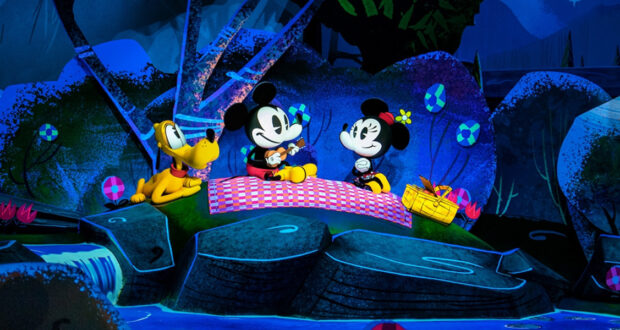 Mickey Mouse and Minnie Mouse enjoy a picnic on a red checkered blanket beside cheerful Pluto, surrounded by bright, cartoon-style scenery with flowers, a basket, and a waterfall as catchy Disney songs play in the background.