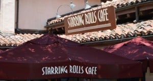 Maroon umbrellas and the "Starring Rolls Cafe" sign outside this Hollywood Studios eatery with its signature tiled roof.