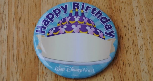 Disney World birthday button featuring cake art and "Happy Birthday" text on wood—celebrate your big day, Disney style!.