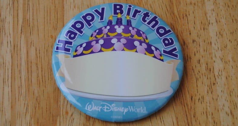 Disney World birthday button featuring cake art and "Happy Birthday" text on wood—celebrate your big day, Disney style!.