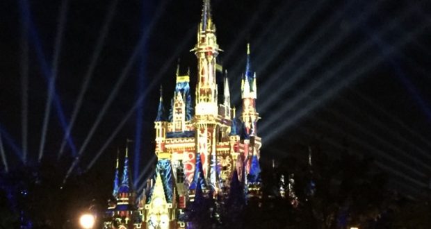Cinderella Castle aglow in vibrant lights and dazzling beams, enchanting guests during Disney World’s iconic nighttime spectaculars.