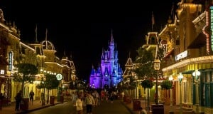 Main Street U.S.A. sparkles at night as crowds head toward Cinderella Castle, soaking up Disney World's magical energy.