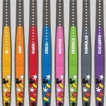 Nine vibrant MagicBands, each personalized with a unique name and Mickey Mouse icons—Disney World essentials for fans.