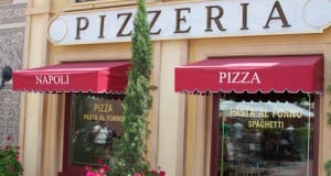 Via Napoli at Disney World beckons with bold red awnings and big windows tempting guests inside for authentic pizza and pasta delights.