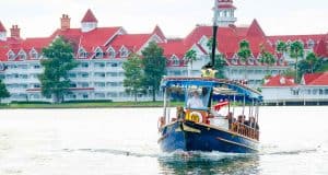 A classic Disney ferry glides across the lake in front of Disney's Grand Floridian Resort, evoking signature Disney magic.