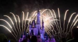 Fireworks light up the night sky behind Cinderella Castle as crowds enjoy the spectacular Disney World nighttime entertainment.