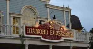 The Diamond Horseshoe sign gleams atop its ornate, balcony-adorned facade in Magic Kingdom at Walt Disney World Resort.