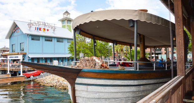 The iconic boat-shaped bar with canopy docks by the Boathouse at Disney Springs, adding to the waterfront magic and fun.