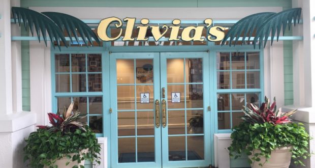 Aqua double doors with “Clivia’s” sign and lush potted plants give off Disney World Resort restaurant vibes.