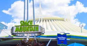 Space Mountain entrance sign at Magic Kingdom, backed by its sleek white building and blue sky—an iconic Disney World adventure.