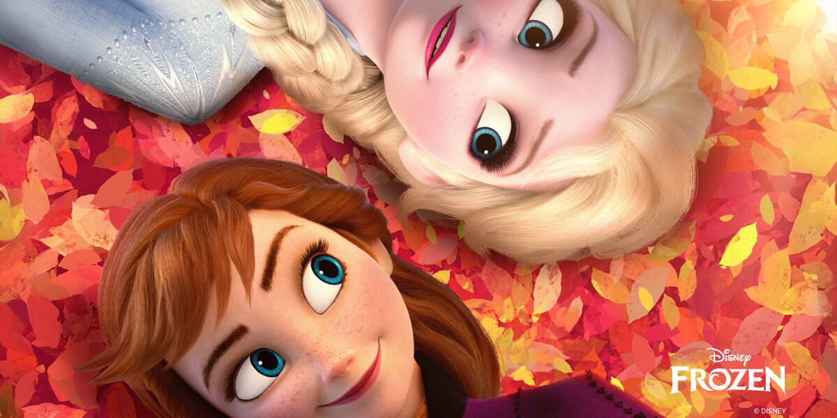 Anna and Elsa from Disney’s Frozen lie on colorful autumn leaves, facing each other with warm, happy expressions. Discover fun Disney facts as the Frozen logo sits in the bottom right corner.