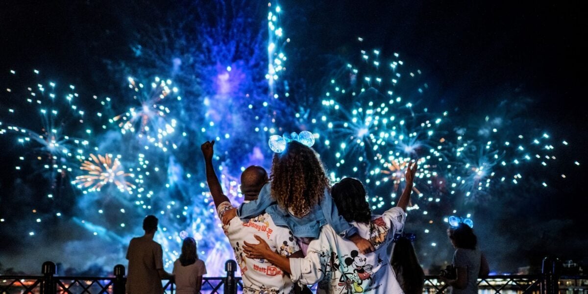 A family stands watching Luminous a Symphony of us at Epcot