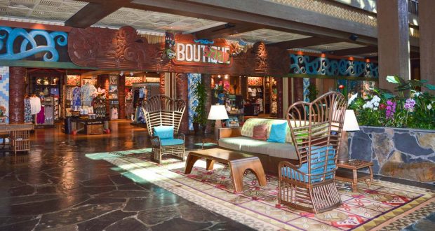 Deluxe Resort lobby at Disney World with tropical vibes, rattan seating, lush plants, and a boutique—pure Disney magic!.