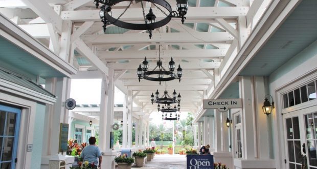 Old Key West Resort’s open house features a chandelier-lit, covered check-in area with white beams and themed event signage.