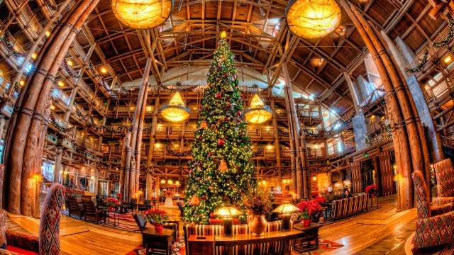Step into a Disney Deluxe Resort lobby aglow with festive lights, towering Christmas tree, and signature grand lodge-style charm.